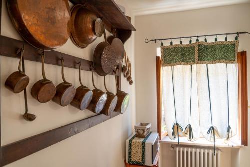 a kitchen with pots and pans hanging on the wall at La Domus di Marta in Volterra