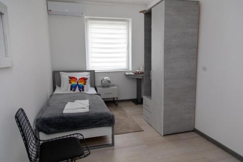 a bedroom with a bed and a chair and a window at VILA Milovanović in Mataruška Banja