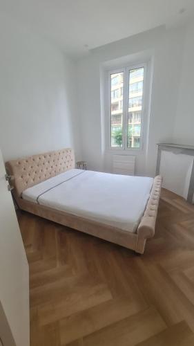 Cette chambre blanche dispose d'un grand lit et de parquet. dans l'établissement Appartement 2 chambres, de luxe, à 50 m de la plage, à Cannes