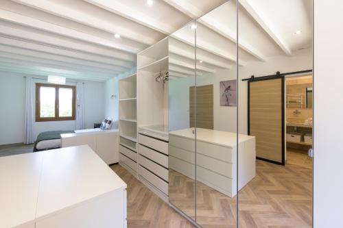 un dressing avec des armoires blanches et une paroi vitrée dans l'établissement Havre Provençal et sa dépendance, à Rocbaron