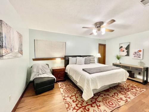 a bedroom with a bed and a table and a fan at Lovely Metairie 1600sft Loft 10 mnts to Hospitals in Metairie