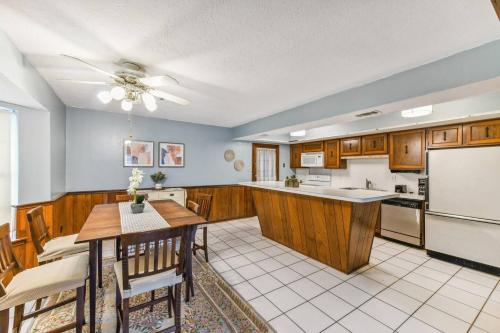 a kitchen with a table and a refrigerator at Lovely Metairie 1600sft Loft 10 mnts to Hospitals in Metairie