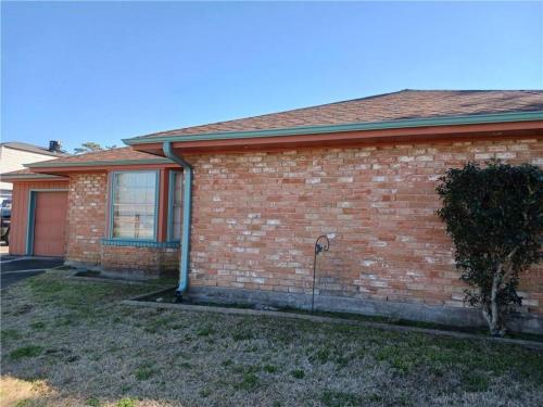 a red brick house with a window and a tree at Lovely Metairie 1600sft Loft 10 mnts to Hospitals in Metairie
