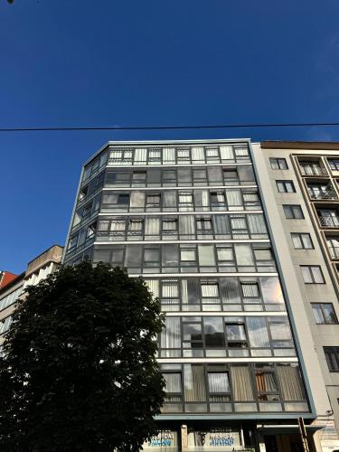 a tall building with a tree in front of it at LUYS Apartment in Brussels