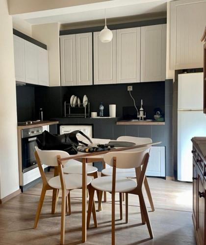 a kitchen with white cabinets and a table and chairs at Venus Apartment in Kŭrdzhali