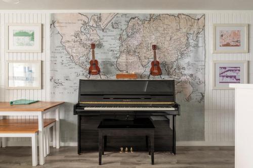 a piano in a room with a map on the wall at Luxury Beachfront Condo in Hauula