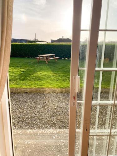 a sliding glass door with a picnic table in a yard at Hynes Self-Catering Midlands Banagher Birr in Birr