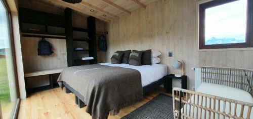 a small bedroom with a bed and a window at Kau Rio Serrano in Torres del Paine