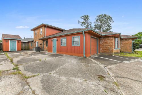 a red house with a driveway in front of it at Lovely Metairie 1600sft Loft 10 mnts to Hospitals in Metairie
