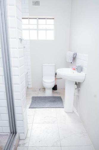 リロングウェにあるSir Harry's Serviced Apartmentsのトイレと洗面台を備えた白いバスルーム