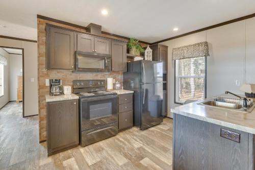 cocina con electrodomésticos de acero inoxidable y suelo de madera en Lakefront Wetumpka Escape with Furnished Deck!, en Wetumpka