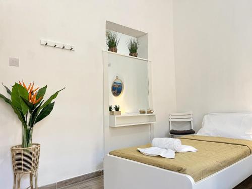 a white room with a bed and a mirror at Maria & Matthias - Apartments in Central of Floriana in Il-Furjana