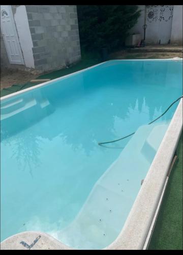 - une piscine d'eau bleue dans une cour dans l'établissement Maison Laurier 3 chambres, à Bagnols-sur-Cèze