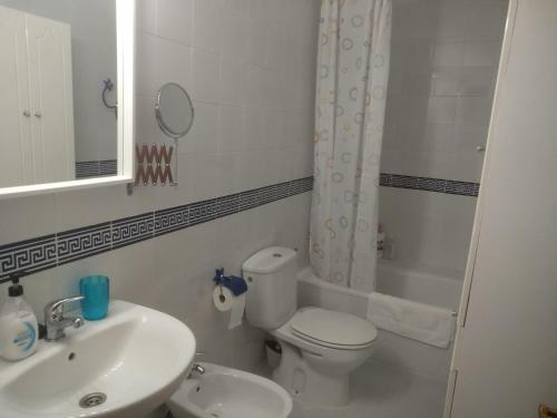 a bathroom with a sink and a toilet and a mirror at Unifamiliar Las Torres in Sanlúcar de Barrameda