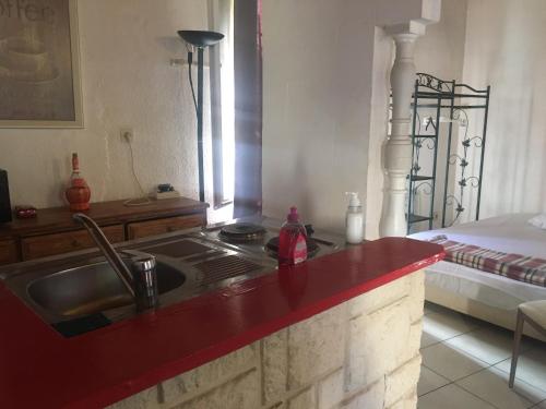 - une cuisine avec un évier et un comptoir rouge dans l'établissement La SixFours Fort Napoleon, à La Seyne-sur-Mer