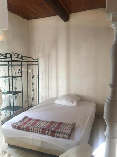 - un lit blanc dans une chambre avec une couverture dans l'établissement La SixFours Fort Napoleon, à La Seyne-sur-Mer