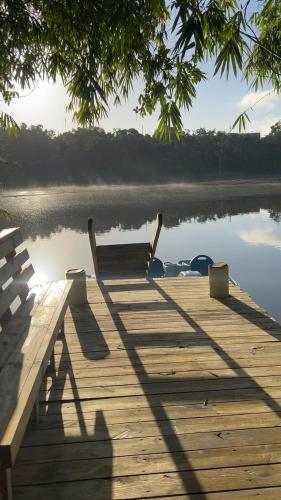 a bench sitting on a dock next to a body of water at HW Tiny Home in Cidra