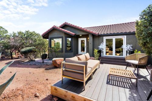 a house with a couch and a chair on a wooden deck at Sage House Modern Retreat 3 Kings, Theater, Gmrm! in Sedona