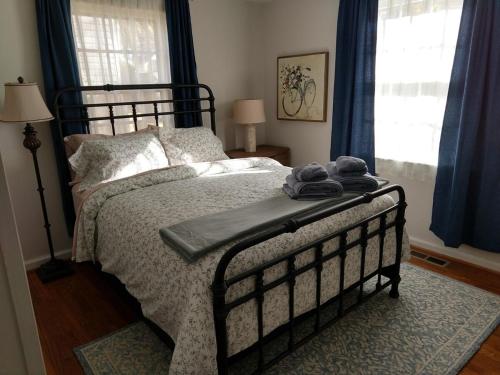 a bedroom with a bed with a blanket and pillows at Charming Classic Cottage 2Br in Durham