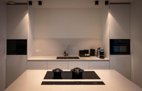 a kitchen with a stove and a sink in it at Portwin luxury stays in Knokke-Heist