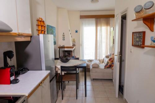 a kitchen with a table and a living room at Emerald Family Maisonette in Siviri