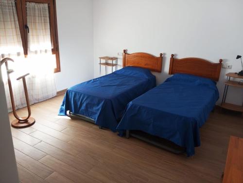two beds with blue sheets in a room at Habitaciones para dormir in Vadocondes