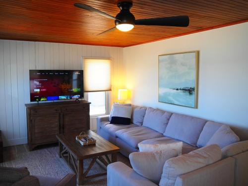 a living room with a couch and a flat screen tv at The Bright And Breezy - Lakefront With Spa! in Frankfort