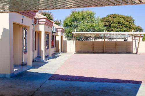 an empty building with a garage and a fence at JTown CBD Self-Catering Apartment in Jwaneng