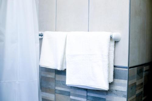 two white towels hanging on a towel rack in a bathroom at JTown CBD Self-Catering Apartment in Jwaneng