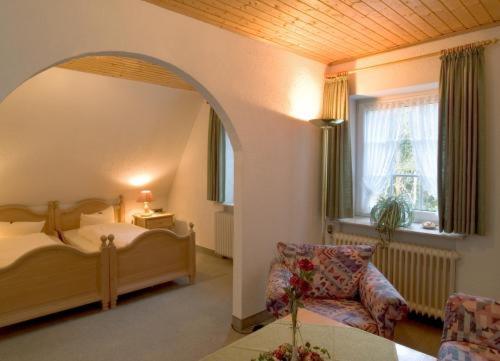 ein Schlafzimmer mit einem Bett, einem Stuhl und einem Fenster in der Unterkunft Hotel Ferien auf der Heid in Eversen