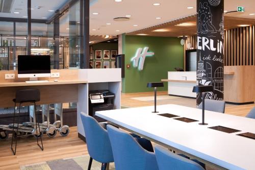 an office with a desk and blue chairs at Holiday Inn Berlin City East Side by IHG in Berlin