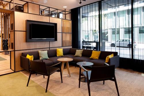 a living room with a couch and a tv at Holiday Inn Berlin City East Side by IHG in Berlin