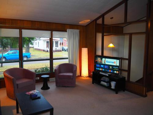 a living room with two chairs and a flat screen tv at New! Namaste Here - Incredible Location! in Frankfort