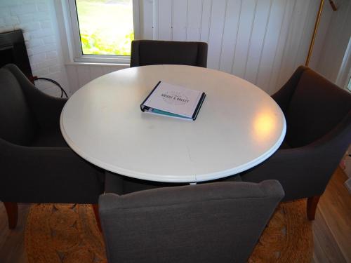 a white table with chairs and a book on it at The Bright And Breezy - Lakefront With Spa! in Frankfort