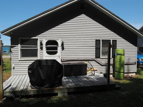 a back porch of a house with a boat at The Bright And Breezy - Lakefront With Spa! in Frankfort