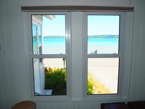 a window with three views of the beach at The Bright And Breezy - Lakefront With Spa! in Frankfort