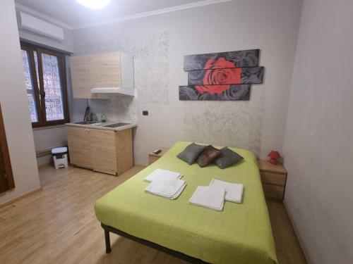 1 dormitorio con 1 cama verde y cocina en RED ROSE, en Roma