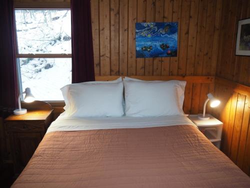 a bedroom with a bed with white pillows and a window at The Crystalaire Cabin - Charming And Relaxing! in Frankfort