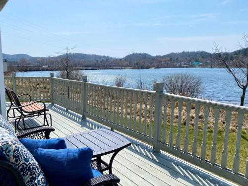 a deck with two chairs and a table and a view of the water at Sunset Bay - Lakefront, Large, And Gorgeous! in Frankfort