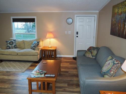 a living room with a couch and a table at The Green Lake Getaway - Shared Lake Access! in Interlochen