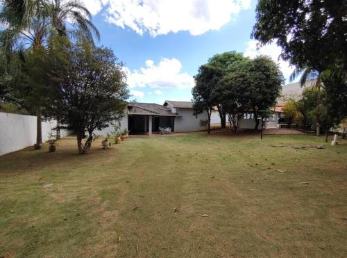a yard of a house with trees and a building at Chácara Jatobá in Espirito Santo Do Pinhal