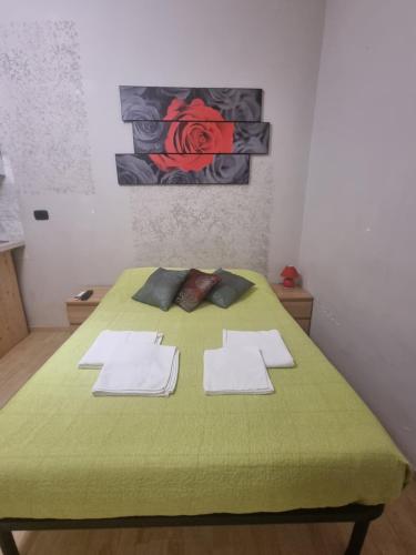 Una cama verde con toallas blancas encima. en RED ROSE, en Roma