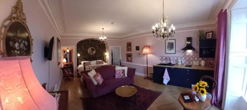 a living room with a purple couch and a table at The Nest at Corbies Rest in Inverness