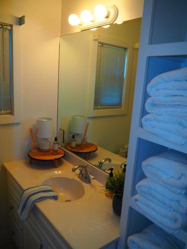a bathroom with a sink and a mirror and towels at The Bright And Breezy - Lakefront With Spa! in Frankfort