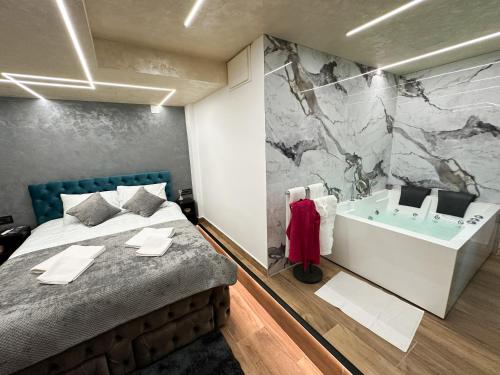 a bedroom with a large bed and a bath tub at Fine apartment in Novi Sad