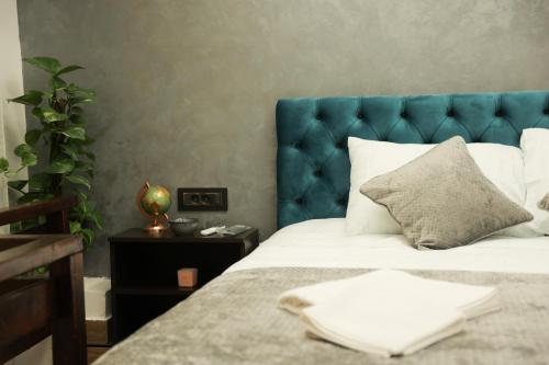 a bedroom with a blue headboard and a white bed at Fine apartment in Novi Sad