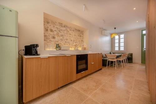 une cuisine avec des armoires en bois et une table à l'intérieur dans l'établissement Villa Spa Arborée Hyper Centre, à La Rochelle