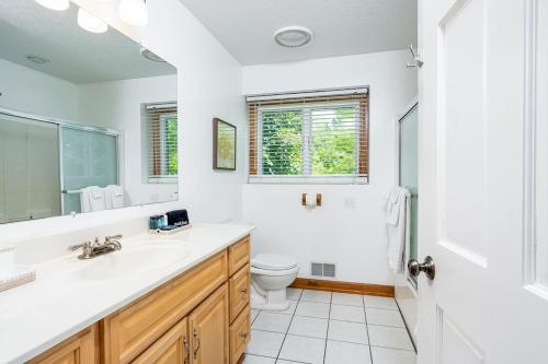 a white bathroom with a sink and a toilet at Sunset Bay - Lakefront, Large, And Gorgeous! in Frankfort