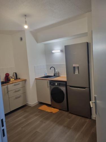 une petite cuisine avec un évier et un réfrigérateur dans l'établissement Appartement au centre ville d'Avignon, à Avignon