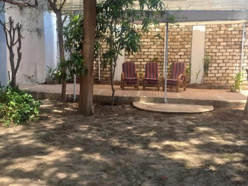two chairs sitting on a swing in a courtyard at Villa Rose-Luxor in Luxor